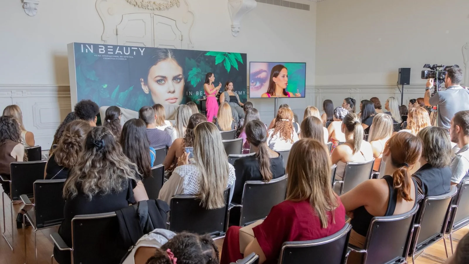 Participantes assistem a uma demonstração de maquilhagem na In Beauty Academy, numa sala do Pavilhão Carlos Lopes.