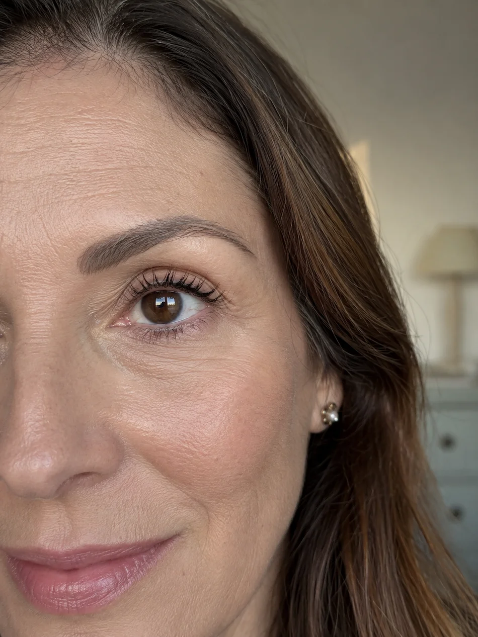 Mulher com mais de 50 anos com máscara apenas nas pestanas superiores, separadas e levantadas.