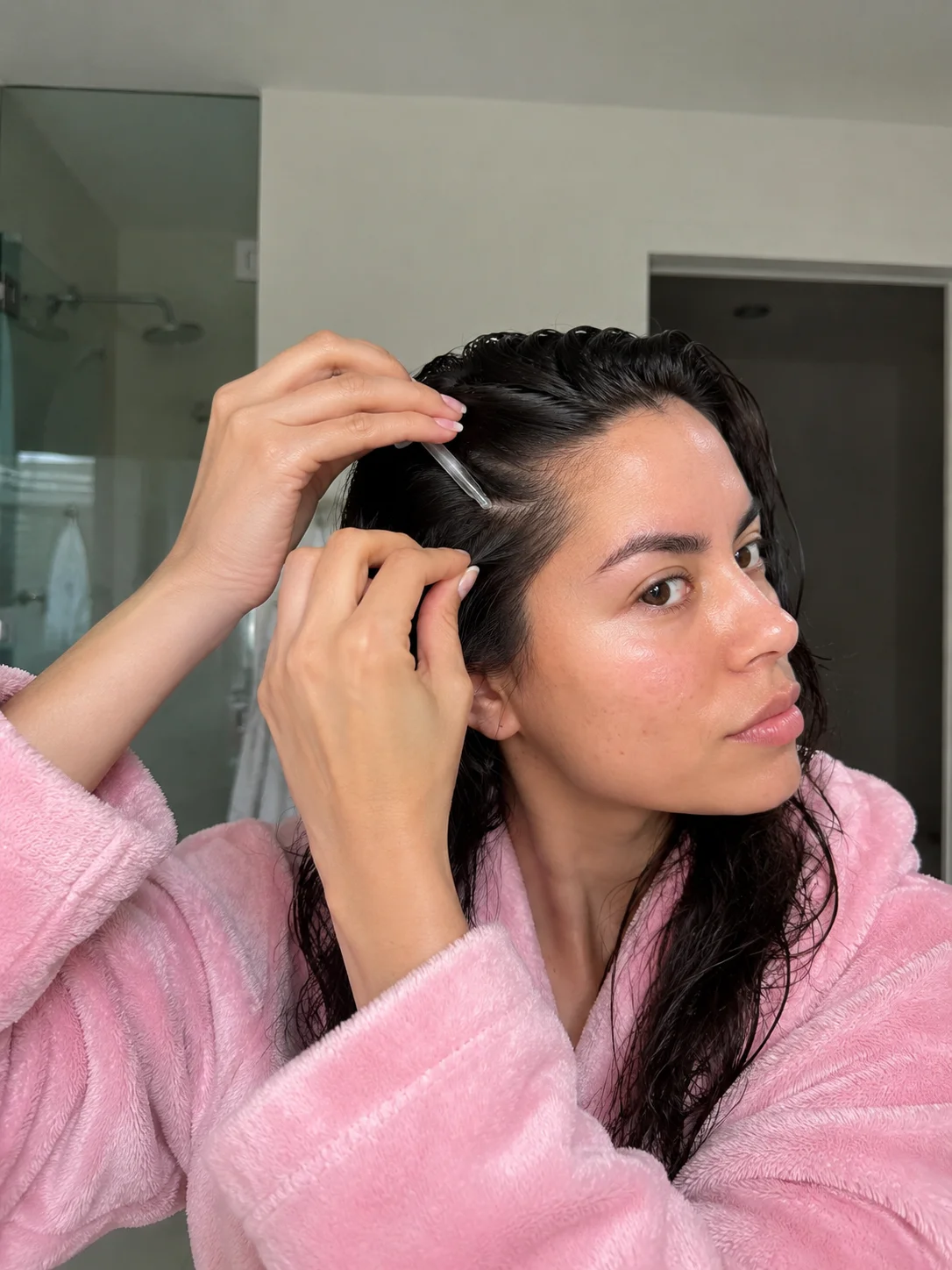Mulher aplica sérum no couro cabeludo com o cabelo molhado