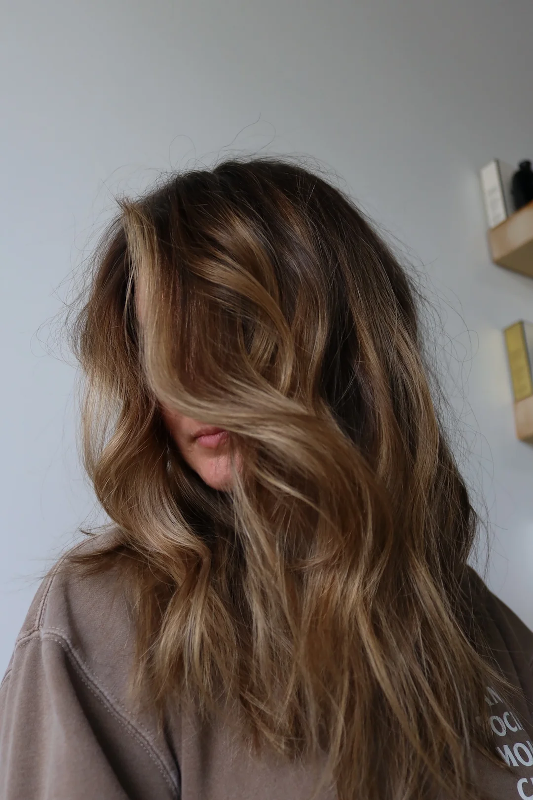Mulher com cabelo fino e ondulado, com volume natural e movimento junto à raiz.
