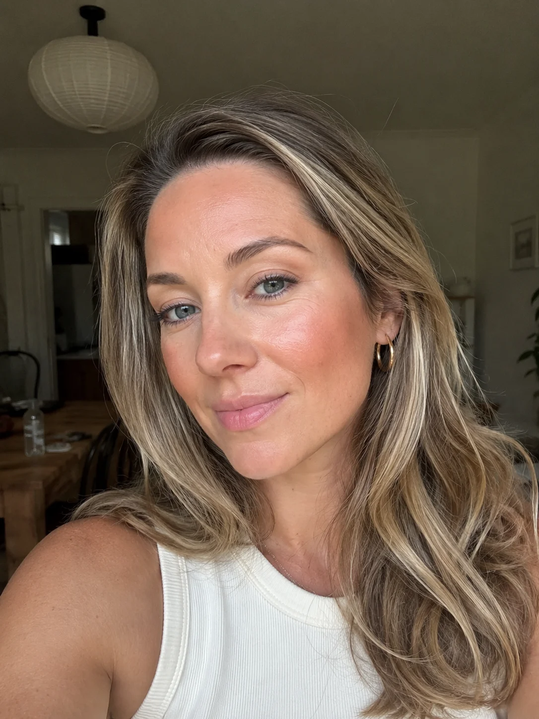 Mulher com blush e bronzer fundidos nas maçãs do rosto no efeito blonzer