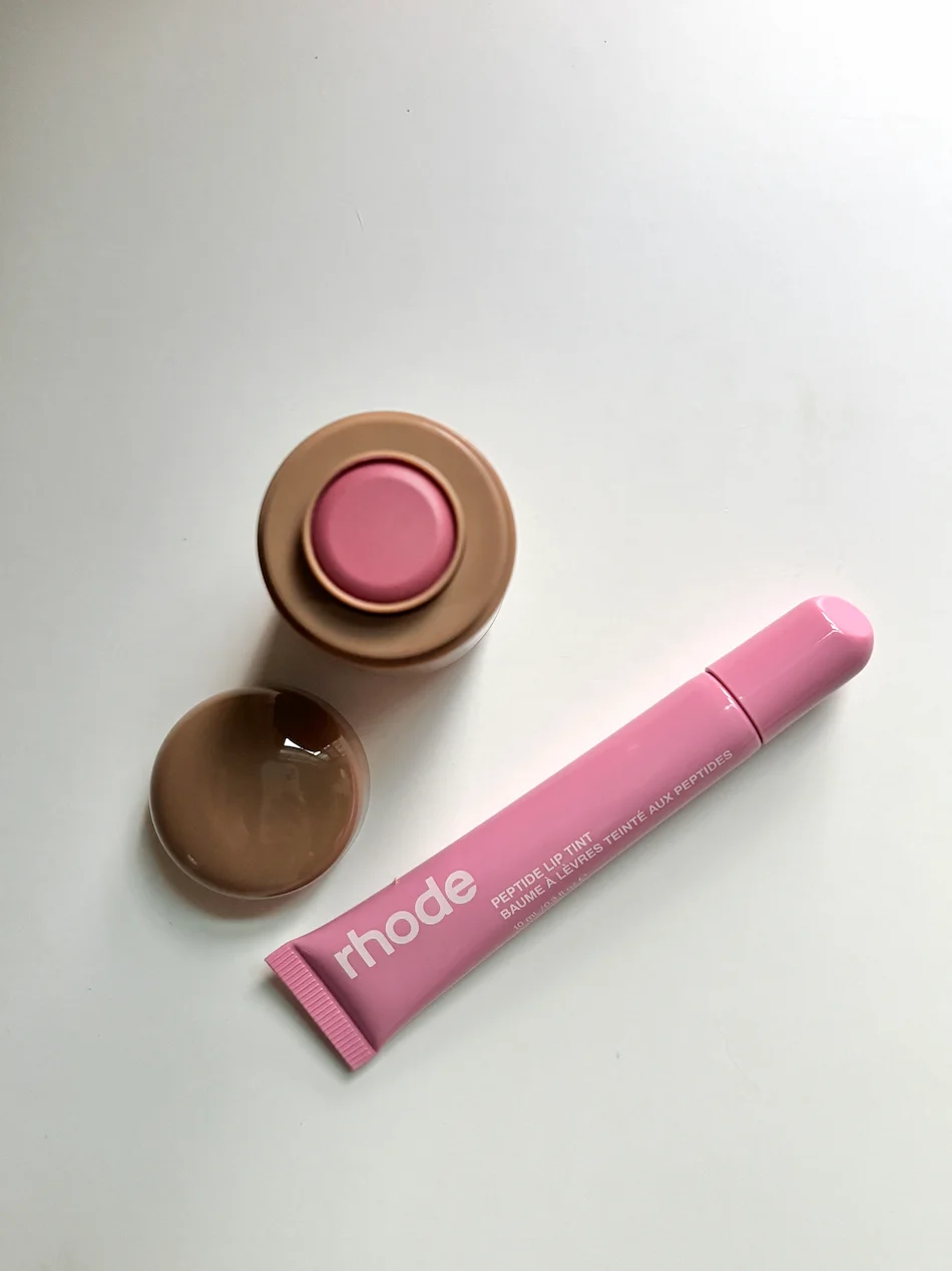 Peptide Lip Tint e Pocket Blush da Rhode em tons rosa sobre uma superfície clara